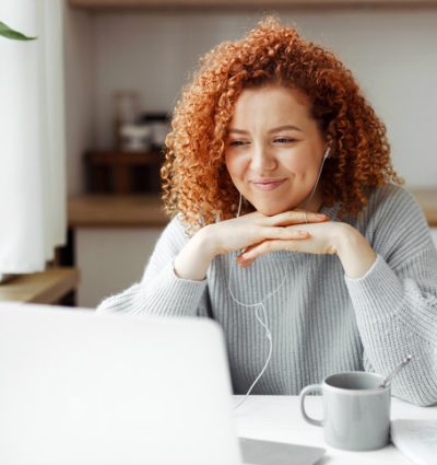 Woman wearing headphones watching laptop