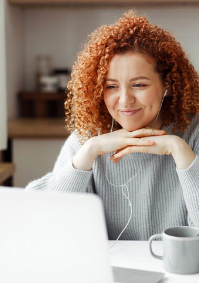 Woman wearing headphones watching laptop